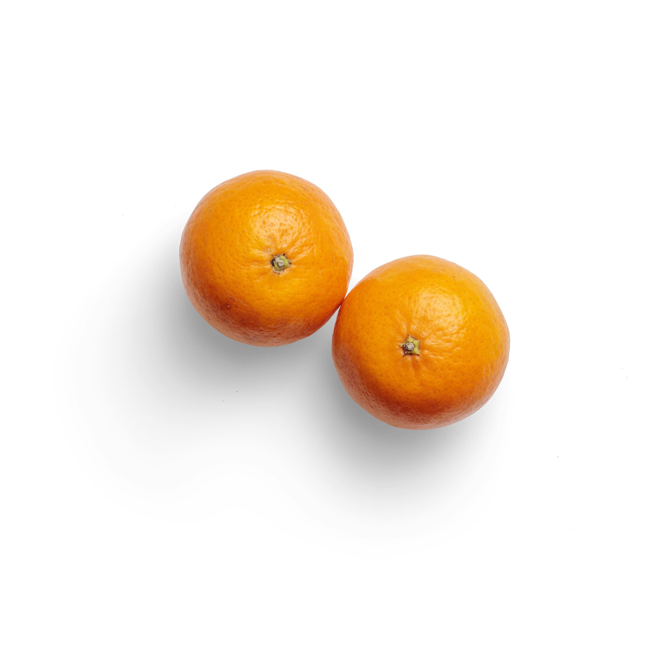 2 orange fruits on white surface