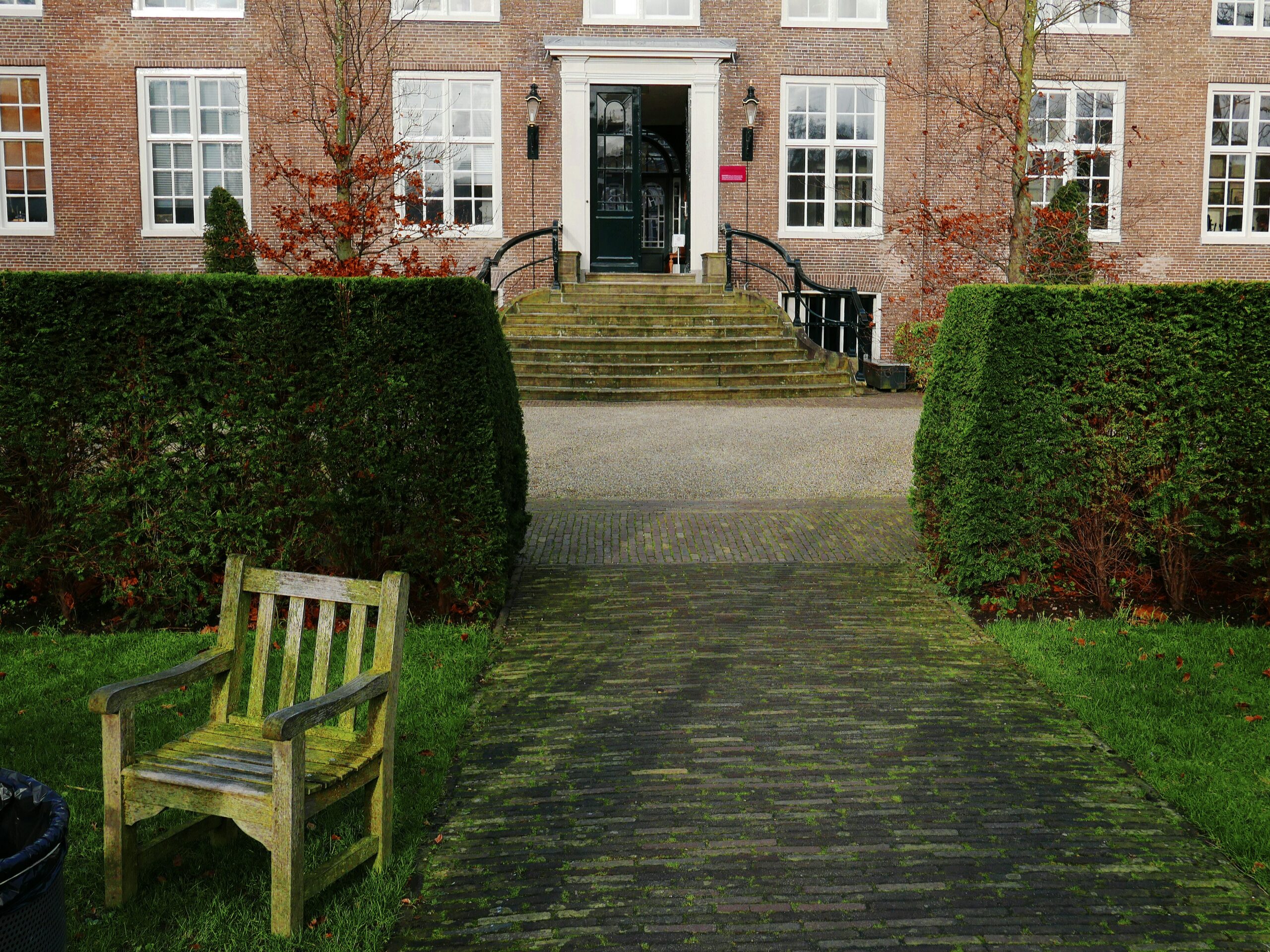 a wooden bench sitting in front of a tall brick building