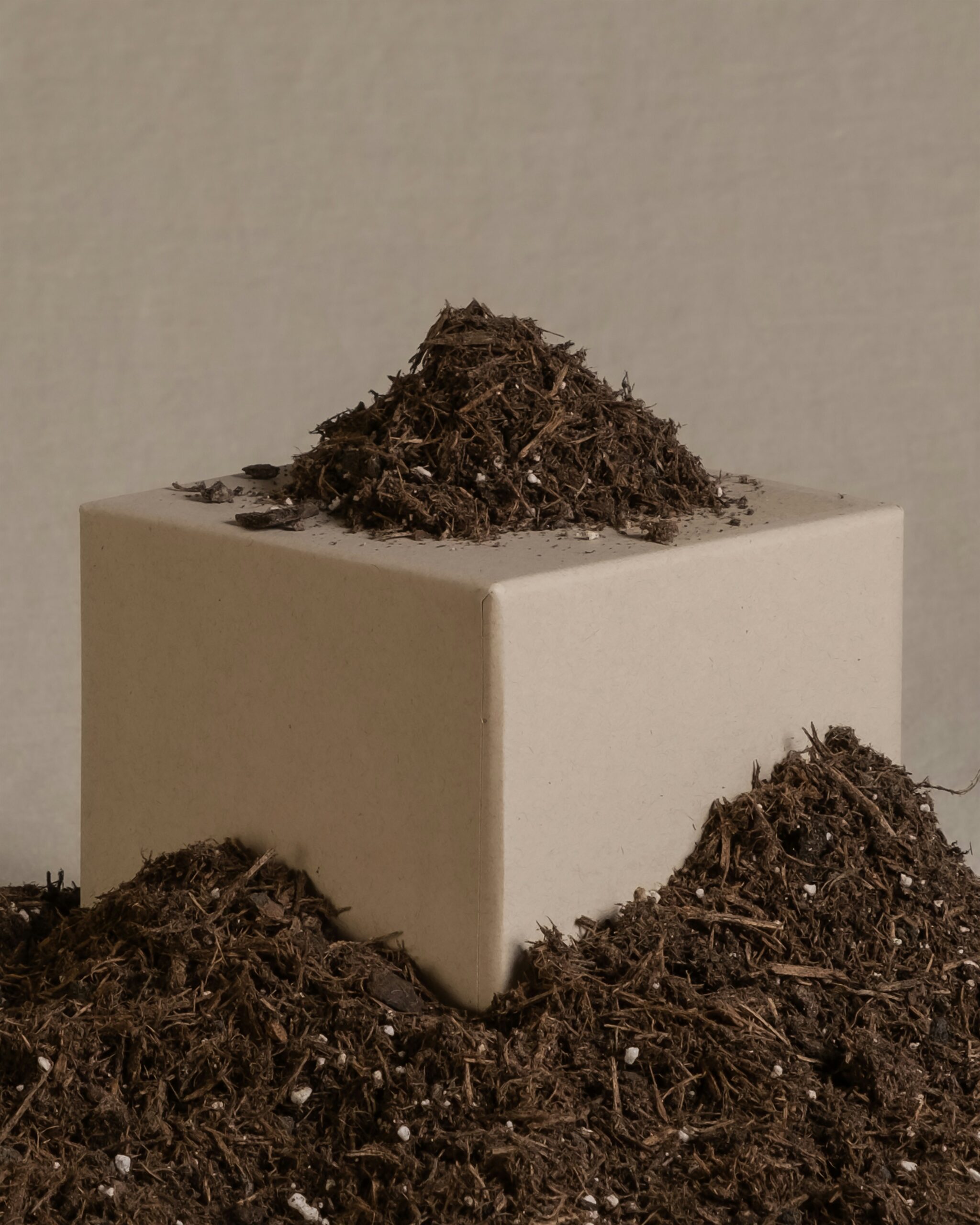 a pile of dirt sitting on top of a white block